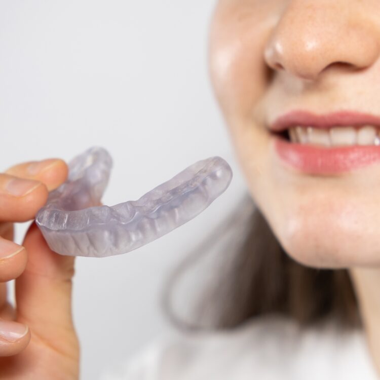 Frau mit Aligner Spange in der Hand