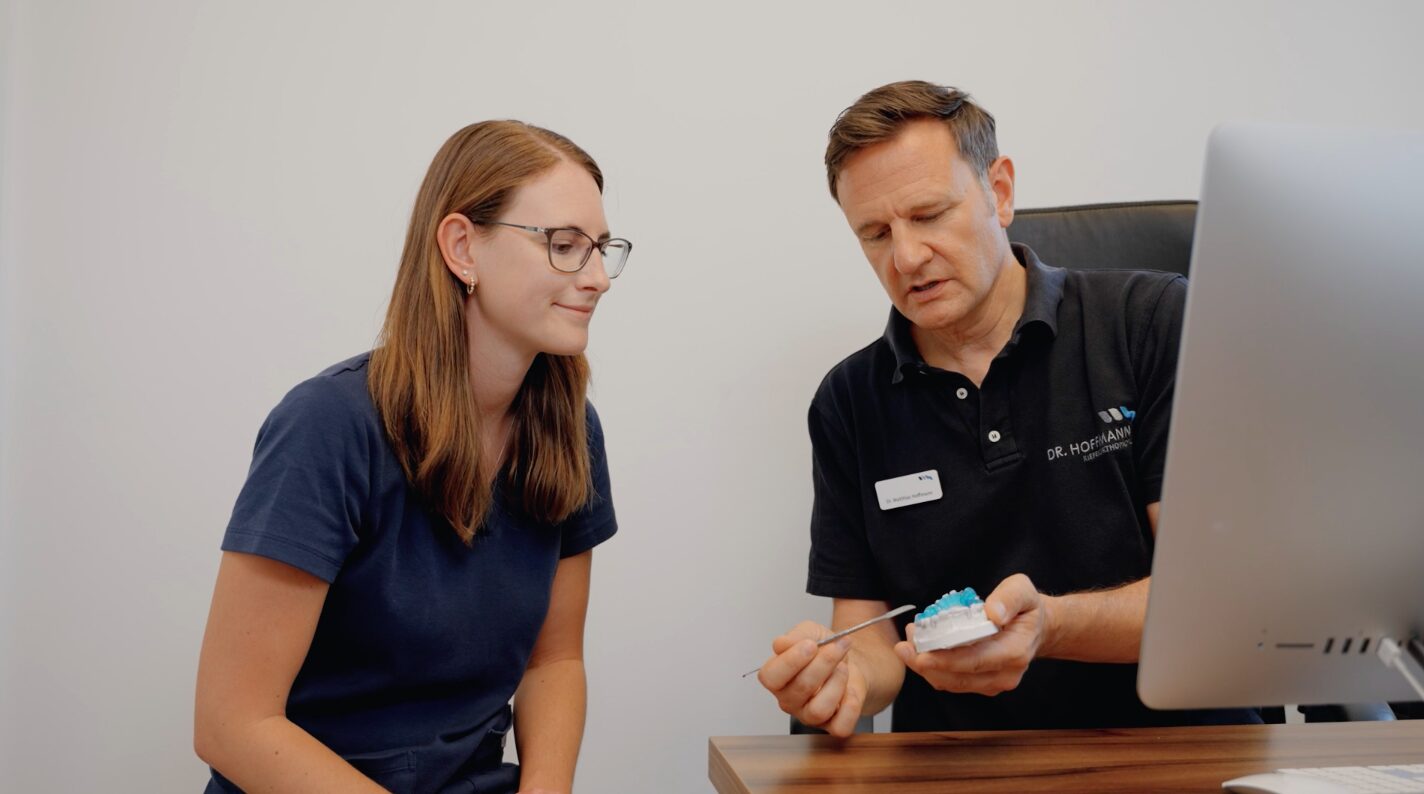 Dr. Hoffmann und Mitarbeiterin mit Modell einer Zahnspange